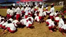 Murid Sekolah Dasar (SD) mengheningkan cipta saat upacara pengibaran bendera di Kantor Pemerintah Kabupaten Jayawijaya, Provinsi Papua, Kamis (17/8). Terlihat sebagian murid  berjongkok karena kelelahan dan mengantuk. (Foto: Fitri Haryanti Harsono)