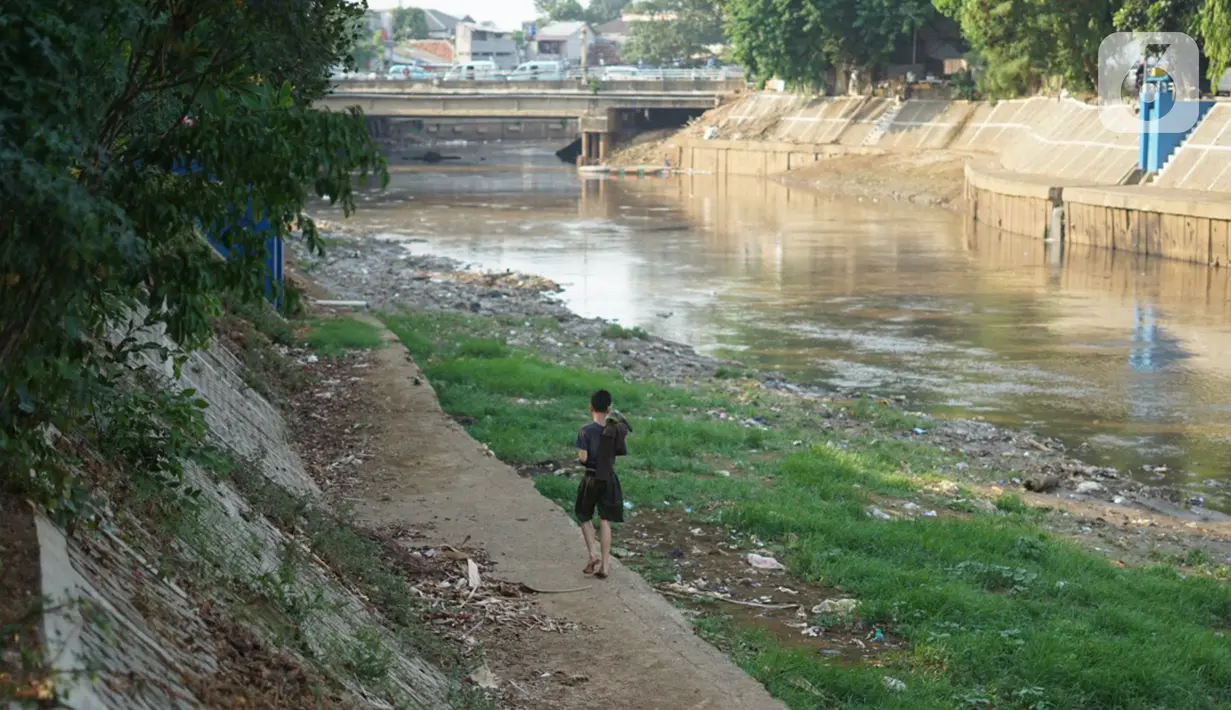 Anak-anak bermain di bantaran Sungai Ciliwung yang mengering, kawasan Kampung Melayu, Jakarta, Jumat (8/11/2019). Curah hujan yang tidak menentu menyebabkan sebagian bantaran Ciliwung masih mengalami kekeringan. (Liputan6.com/Immanuel Antonius)