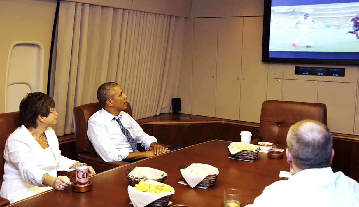 Bersama penasihat senior kepresidenan, Valerie Jarrett (kiri), orang nomor satu di Amerika Serikat, Barrack Obama menyaksikan laga Sam's Army melawan Der Panzer di atas pesawat Air Force One, (26//6/2014). (REUTERS/Larry Downing)
