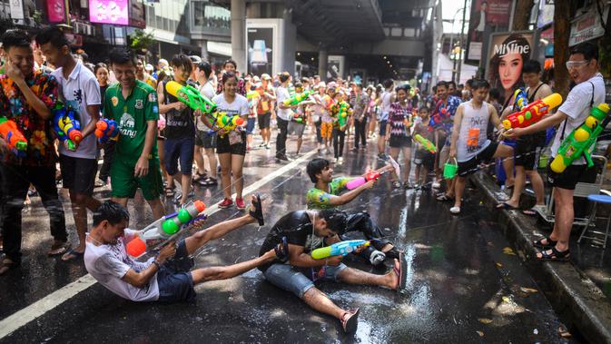 Warga bersuka ria saat perang air dalam Festival Songkran atau Tahun Baru Thailand di Bangkok, 14 April 2019. Perang air menimbulkan kemacetan di jalanan seantero kota. (Permata SAMAD/AFP)