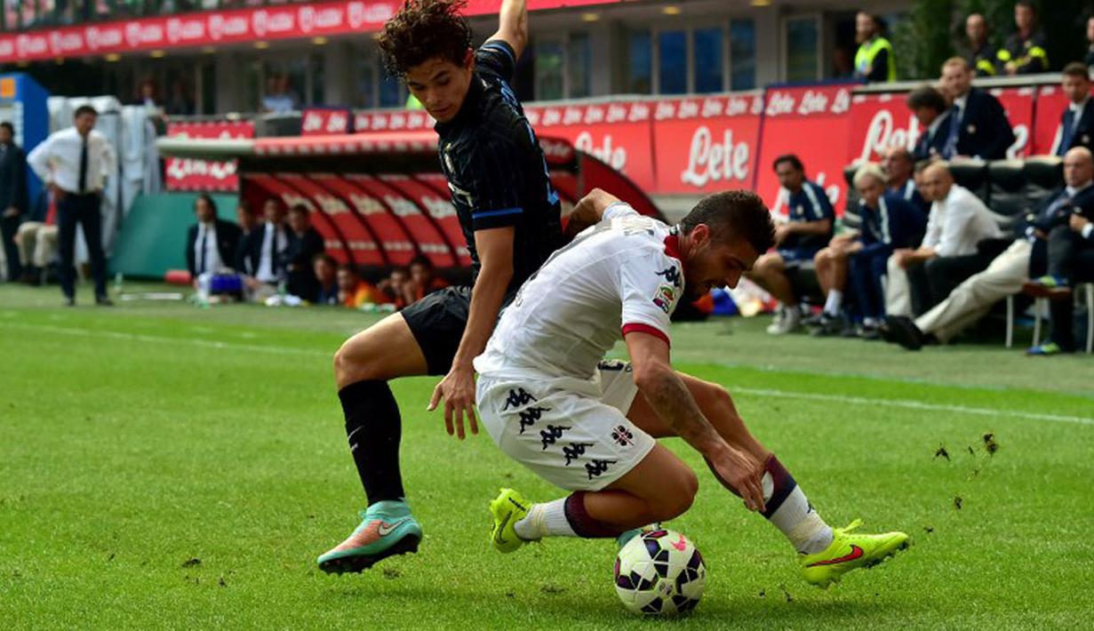 Pemain belakang Cagliari, Antonio Balzano (kanan), berusaha menahan laju penyerang Inter Milan, Dodo, saat berlaga dilanjutan Serie A Italia di Stadion San Siro, Milan, (28/9/2014). Inter Milan kalah 1-4 dari Cagliari. (AFP PHOTO/Giuseppe Cacace)