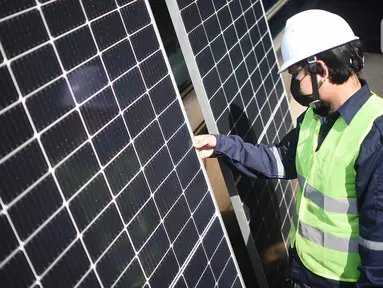 Pekerja memeriksa panel surya Utomo SolaRUV di Jakarta, Kamis (16/09/2021). Sistem mengubah energi cahaya matahari menjadi energi listrik menggunakan panel surya Utomo SolaRUV menjadi sumber energi yang ramah lingkungan serta mengurangi emisi gas rumah kaca. (Liputan6.com/HO/Andrey)