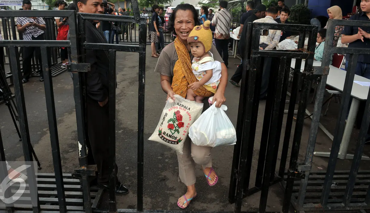 Warga membawa Paket  Sembako Murah oleh  PT Indosiar Visual Mandiri  di Studio 5 Indosiar, Jakarta, (10/6). Pembagian  Sembako Murah ini hanya di sekitaran wilayah kerja perusahaan PT Indosiar di Jalan Daan Mogot. (Liputan6.com/Johan Tallo)