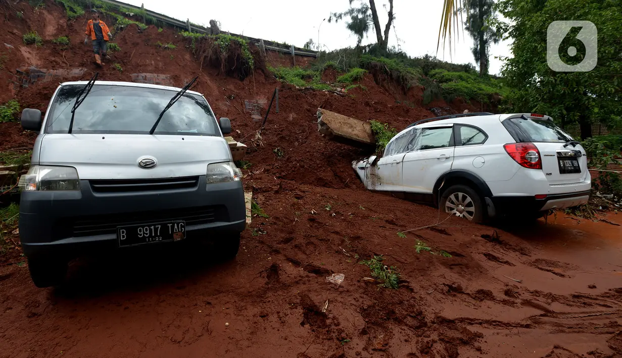 Dua mobil tertimpa longsoran dinding ruas jalan Tol JORR Cikunir, Bekasi, Jawa Barat, Kamis (2/1/2020). Hujan deras pada malam Tahun Baru 2020 membuat sejumlah titik jalan tol rawan longsor dan banjir. (merdeka.com/Imam Buhori)