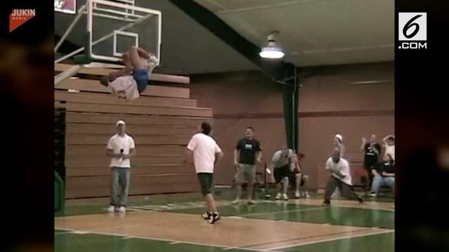 Seorang pemain basket tersangkut di ring usai melakukan dunk ke keranjang tim lawan. Bagian tubuh yang tersangkut jaring ring itu adalah kakinya.