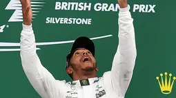 Lewis Hamilton melempar trofi diatas podium setelah berhasil memenangkan GP Inggris di sirkuit Silverstone, (16/7). Hamilton juga tercatat telah lima kali menjuarai GP Inggris (2008, 2014, 2015, 2016, dan 2017). (AFP Photo/Ben Stansall)
