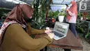 Karyawan mengupload foto tanaman hias untuk dipasarkan secara online di Titik Hijau, Bojongsari, Depok, Jawa Barat, Senin (26/10/2020). Pada masa pandemi COVID-19, dalam sebulan pedagang rata-rata mempu menjual 50 tanaman hias dengan omzet ratusan juta rupiah. (merdeka.com/Arie Basuki)