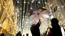 Seorang wanita dengan payung berpose di bawah lampu yang menghiasi jalan Nikolskaya di Moskow, Senin (18/12). Salah satu sudut kota di Rusia itu didekorasi dengan lampu dan pernak-pernik perayaan Natal dan Tahun Baru. (AP Photo/Pavel Golovkin)
