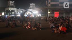 Sejumlah pengunjung duduk di bangunan instalasi pada acara "Pestapora 2022" di Gambir Expo Kemayoran, Jakarta, Sabtu (24/9/2022). Pada acara pertunjukan musik Indonesia yang berlangsung 23-25 September 2022 tersebut menghadirkan enam panggung pertunjukan dengan menampilkan berbagai musisi tanah air. (Liputan6.com/Herman Zakharia)