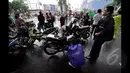 Seorang Pengendara saat melihat mesin motornya yang mati akibat melewati banjir, Jakarta, Senin (6/2/2015).  Hujan yang turun sejak malam hingga kini membuat sejumlah ruas jalan tergenang air. (Liputan6.com/Faizal Fanani)