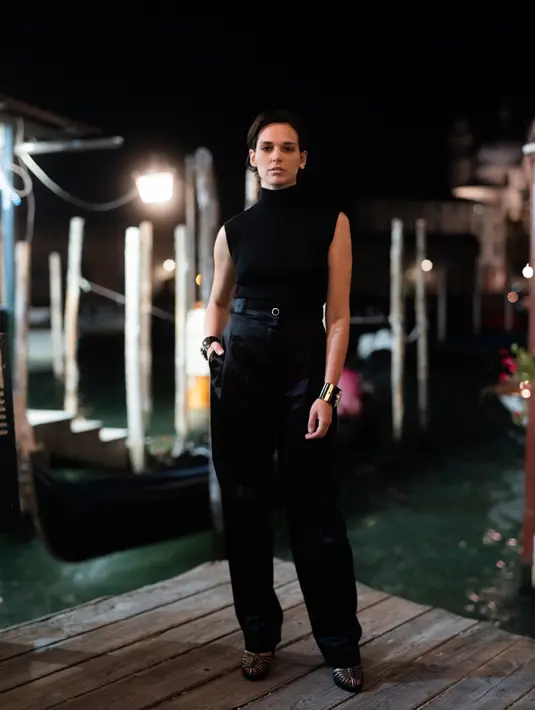 Sara Serraiocco memakai atasan hitam dan celana satin dari koleksi  Métiers d’art 2020/21 