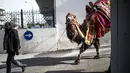Seorang pria menarik untanya menuju tempat bergulat dalam Selcuk Camel Wrestling Festival di Kota Selcuk, Turki, Minggu (20/1). Hewan yang dijadikan peserta gulat ini adalah unta persilangan yang dilatih sejak kecil untuk kompetisi. (BULENT KILIC/AFP)