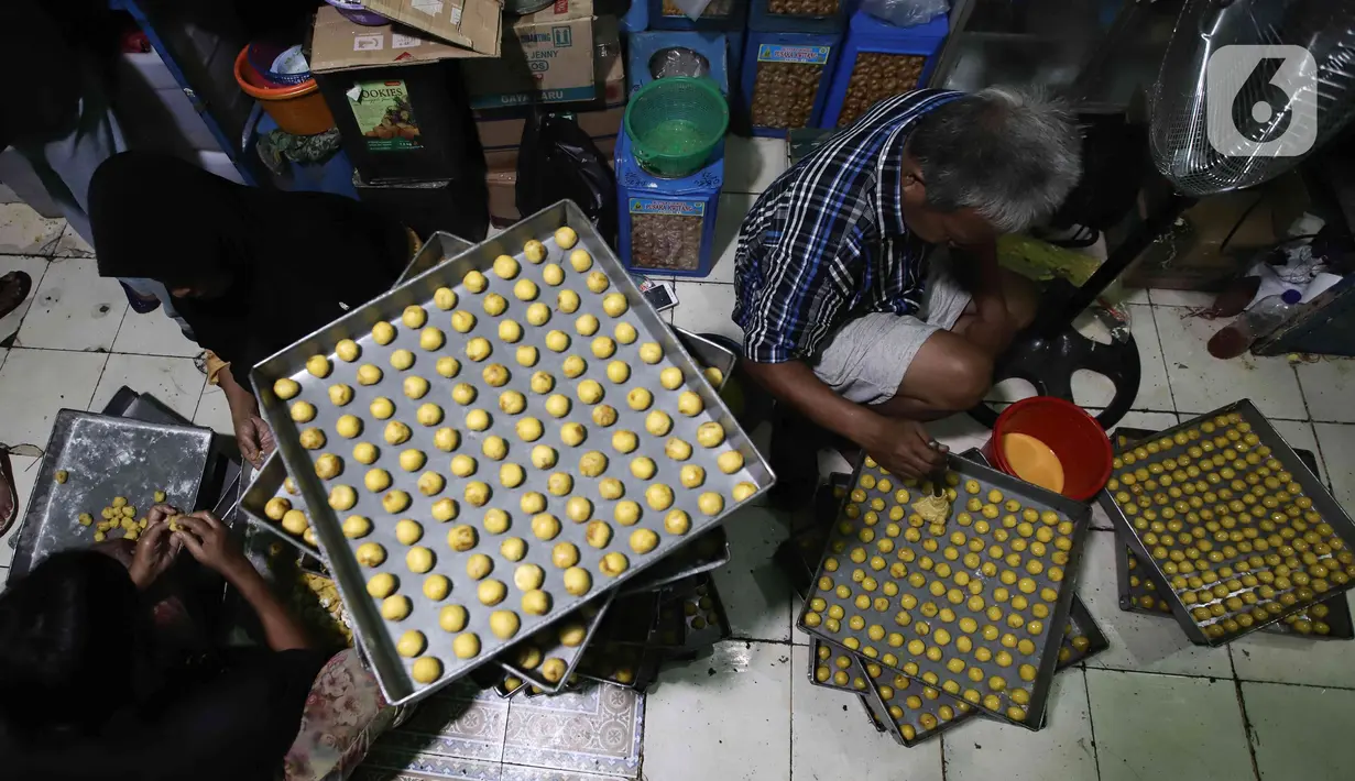 Para pekerja menyelesaikan pembuatan kue kering skala rumah tangga Pusaka Kwitang di kawasan Senen, Jakarta, Rabu (13/4/2022). Harga jual kue kering Ramadhan naik dari Rp 70.000 per kilogram pada tahun lalu menjadi Rp 80.000 - Rp 85.000 per kilogram. (Liputan6.com/Herman Zakharia)