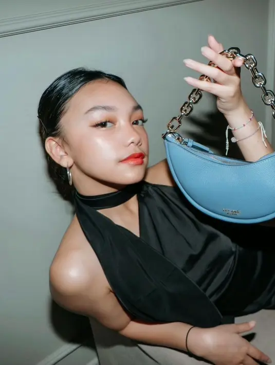 Halter dress warna hitam dengan aksen cut out pada kerah yang meningkatkan penampilan ala gadis fashion. (Foto: Instagram @naura.ayu)