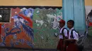 Pelajar melintasi tembok bergambar burung merak yang merupakan khas batik Sidoarjo di Kampung batik, Sidoarjo, Senin (31/03/2015). Produksi batik Kota Sidoarjo ini sejak tahun 1960-an hingga saat ini masih tetap bertahan. (Liputan6.com/Andrian M Tunay)