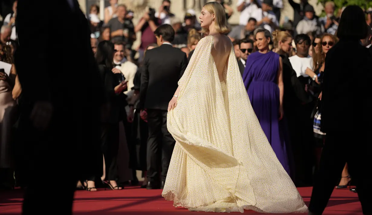 Elle Fanning berjalan di karpet merah dengan mengenakan gaun semi-sheer Gucci dengan potongan backless yang dramatis. (Photo by Andreea Alexandru/Invision/AP)
