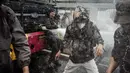 Pihak kepolisian yang berjaga berusaha membubarkan massa tersebut dengan menembakkan gas air mata ke arah pengunjuk rasa. (YASUYOSHI CHIBA/AFP)