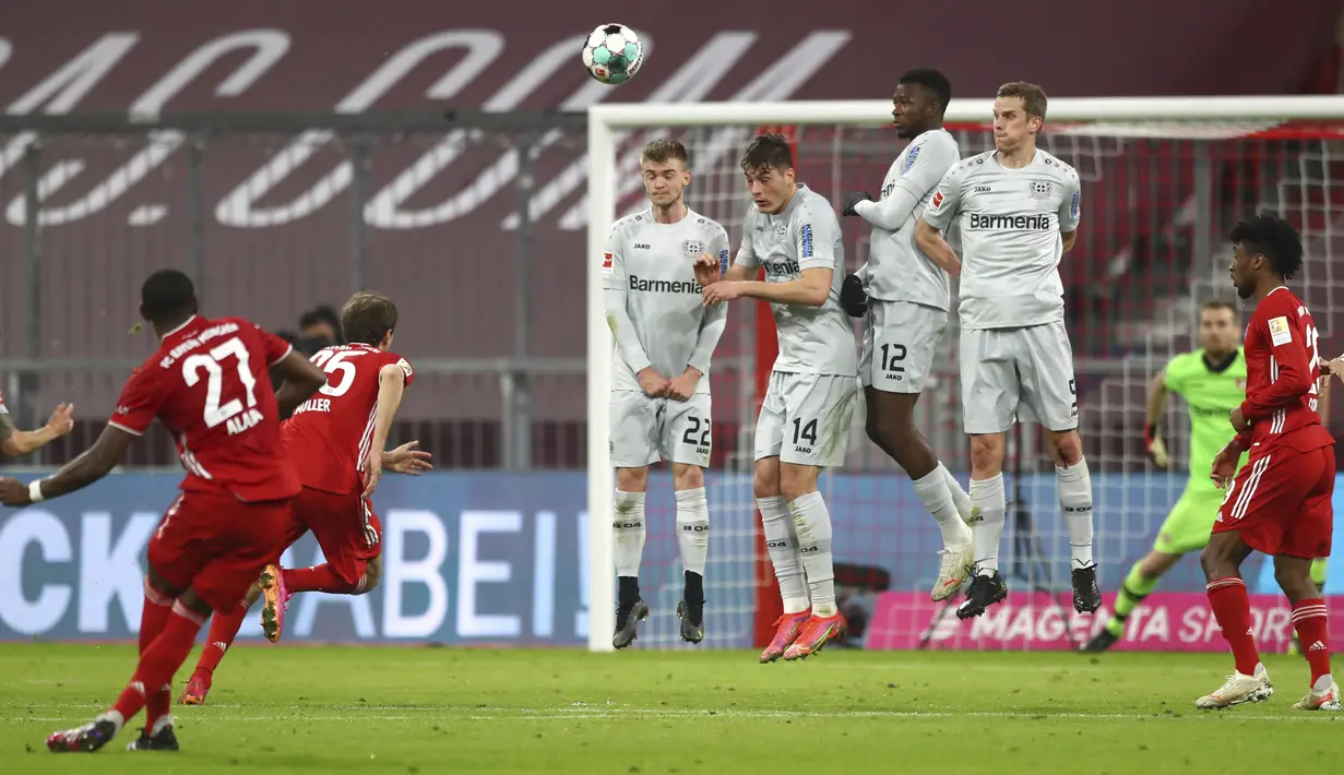 Pemain Bayern Munchen David Alaba melakukan tendangan bebas saat melawan Bayer Leverkusen pada pertandingan Bundesliga di Stadion Allianz Arena, Munchen, Jerman, Selasa (20/4/2021). Bayern Munchen menang 2-0. (AP Photo/Matthias Schrader, Pool)