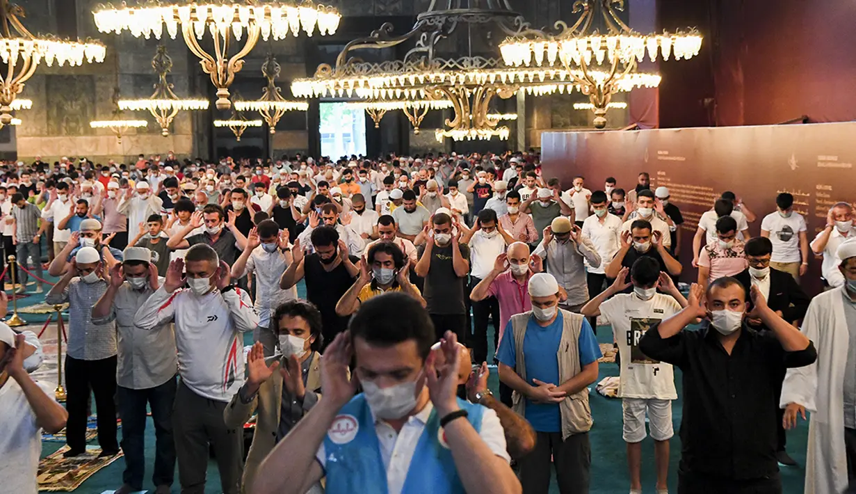 Jemaah mengenakan masker dan menerapkan jaga jarak untuk menghindari penularan COVID-19 saat melaksanakan salat Idul Adha di Hagia Sophia, Istanbul, Turki, Jumat (31/7/2020). Ini merupakan salat Idul Adha pertama di Hagia Sophia setelah dialihfungsikan dari museum menjadi masjid. (Pool via AP)