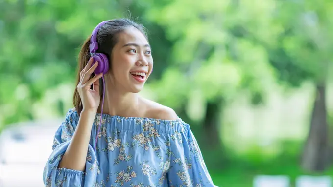 perempuan bahagia mendengarkan musik