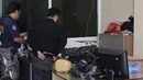 Petugas BNN memeriksa sabu yang dibungkus plastik hitam hingga beberapa kantong saat penggerebekan sebuah hotel di Tanah Abang, Jakarta, Jumat (29/1). Diduga penggerebekan terkait pengembangan kasus sabu 100 kg di Jepara. (Liputan6.com/Herman Zakharia)