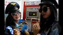 Dua orang Pramuniaga menunjukan beberapa kartu E-money yang dapat digunakan untuk pembayaran parkir di Terminal Parkir Elektronik (TPE), Jakarta, Kamis (29-01-2015). Sebanyak enam bank terlibat dalam sistem pembayaran ini. (Liputan6.com/Andrian M Tunay)
