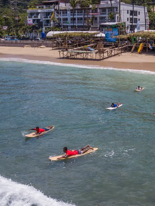 Para peserta berenang menuju area perlombaan dalam Kontes Selancar Phuket 2020 di Pantai Kalim di Phuket, Thailand (14/9/2020). Acara yang berlangsung selama tiga hari itu merupakan bagian dari kampanye pemerintah Thailand untuk mempromosikan pariwisata dan merangsang perekonomian. (Xinhua/Zhang Ker
