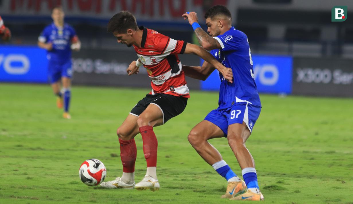 Pemain Persib Bandung, Berguinho menjaga ketat pemain Madura United pada laga pekan ke-23 BRI Super League 2025/2026 di Stadion Gelora Bandung Lautan Api (GBLA), Kota Bandung, Kamis (26/2/2026) malam WIB. (Bola.com/Erwin Snaz)