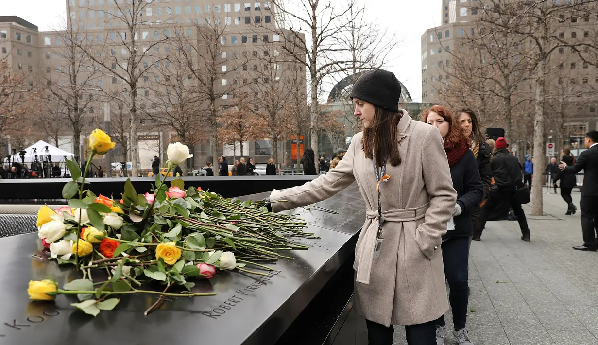 Orang-orang menaruh bunga mawar dalam peringatan 25 tahun serangan bom truk di WTC, New York City, Amerika Serikat, Senin (26/2). Serangan bom truk terjadi pada 26 Februari 1993. (Spencer Platt/Getty Images/AFP)