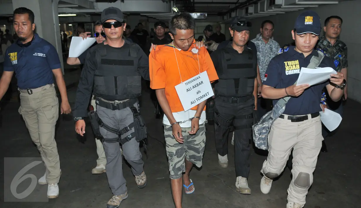 Ali Tomket berjalan menuju loket parkir saat reka ulang pembunuhan di Mall kawasan Senayan, Jakarta, Jumat (2/10/2015). Ali Tomket selain membunuh ia juga membawa kabur uang Rp 2,3 juta.(Liputan6.com/Andrian M Tunay)