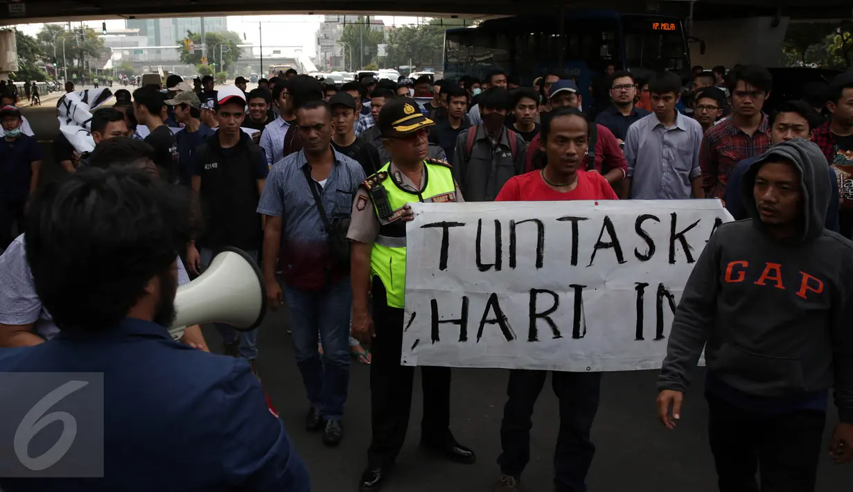 Mahasiswa Trisakti membawa spanduk bertuliskan “Tuntaskan hari ini" saat aksi menutup Jalan Kyai Tapa, Jakarta Barat, Jumat (2/9). Aksi itu mendesak penyelesaian kisruh masalah internal antara rektorat dengan yayasan kampus. (Liputan6.com/Johan Tallo)