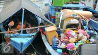 Sejumlah anak penghuni pasar ikan Penjaringan berada di atas perahu saat rumahnya mulai dihancurkan oleh alat berat petugas, Jakarta, Senin (11/4). Pemprov DKI membongkar ratusan rumah di wilayah Pasar Ikan. (Liputan6.com/Yoppy Renato)