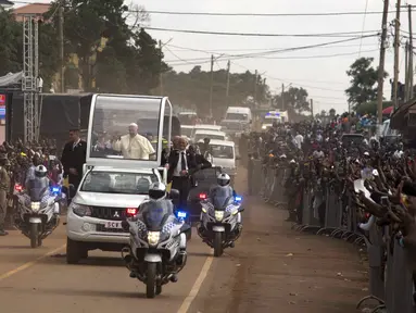 Ribuan warga Uganda berbaris dijalan memberikan sambutan yang meriah untuk Paus Francis yang ingin berceramah di kuil Uganda Martir di Namugongo, Uganda, (28/11). (REUTERS/Edward Echwalu)