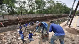 Pekerja Dinas Sumber Daya Air Jaktim menyelesaikan perbaikan turap di daerah aliran Kali Sunter, Jakarta, Rabu (31/10). Perbaikan ini merupakan bagian proyek normalisasi kali guna antisipasi banjir di kala musim penghujan. (Merdeka.com/Iqbal S. Nugroho)