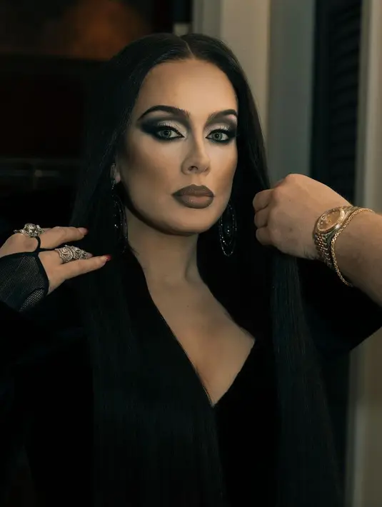 Penyanyi Adele tampil dengan karakter Morticia Addams. Ia mengenakan riasan smokey, dan dress hitam berdada rendah. [@adele]