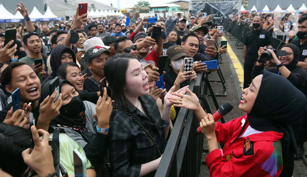Vokalis grup band Kotak bernyanyi bersama penonton saat tampil pada acara doa bersama dan konser amal Salam Satu Jiwa di Bekasi, Jawa Barat, Minggu (8/1/2023). Konser ini merupakan bentuk dukungan dan solidaritas terhadap korban tragedi Kanjuruhan Malang. (Liputan6.com/Herman Zakharia)