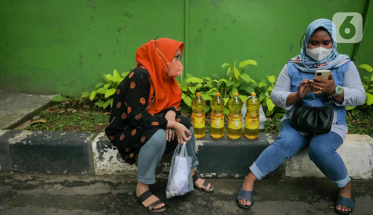 Dua perempuan beristirahat seusai antre membeli minyak goreng di Polsek Tebet, Jakarta Selatan, Jumat (4/3/2022). Polres Metro Jakarta Selatan akan menggelar operasi pasar minyak goreng selama enam hari, terhitung mulai hari in, 4 hingga 9 Februari mendatang. (Liputan6.com/Herman Zakharia)