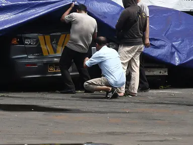 Petugas melihat melihat kondisi mobil yang dirusak di Polsek Ciracas, Jakarta, Rabu (12/12). Mobil yang dirusak di antaranya mobil polisi dan mobil Puspom Kodam. (Liputan6.com/Herman Zakharia)