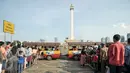 Sejumlah warga antri untuk menaiki kereta wisata di halaman Monumen Nasional, Jakarta, Kamis (7/7). Libur kedua Lebaran dimanfaatkan warga untuk bekunjung ke lokasi wisata bersama keluarga. (Liputan6.com/Yoppy Renato)