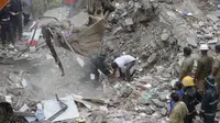 Tim penyelamat mengevakuasi korban akibat runtuhnya gedung lima lantai di Mumbai, India, Selasa (25/7). Sebuah gedung penghunian lima lantai runtuh pada selasa pagi waktu setempat. (AP/Rafiq Maqbool) 
