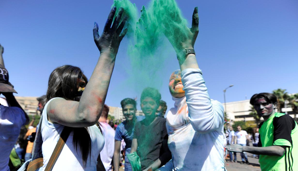Peserta melempar bubuk berwarna saat acara marathon bertajuk 'I Love Damaskus' di Umayyah Square Damaskus, Suriah, Jumat (7/10). (REUTERS / Omar Sanadiki)