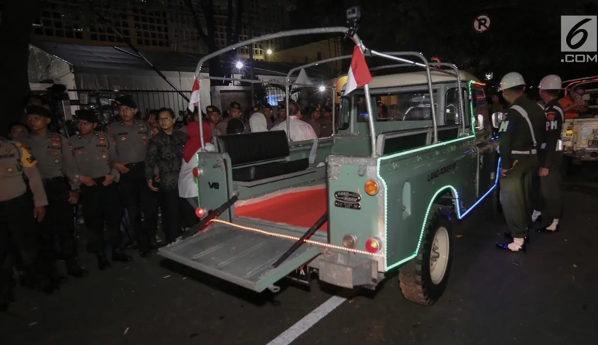Petugas mengatur parkir mobil Land Rover klasik bak terbuka tumpangan Jokowi-Ma`ruf di gedung KPU Pusat, Jakarta, Jumat (21/9). Jokowi-Ma`ruf ke KPU untuk mengambil nomor urut Pilpres pasangan Capres dan Wapres 2019- 2024. (Liputan6.com/Fery Pradolo)