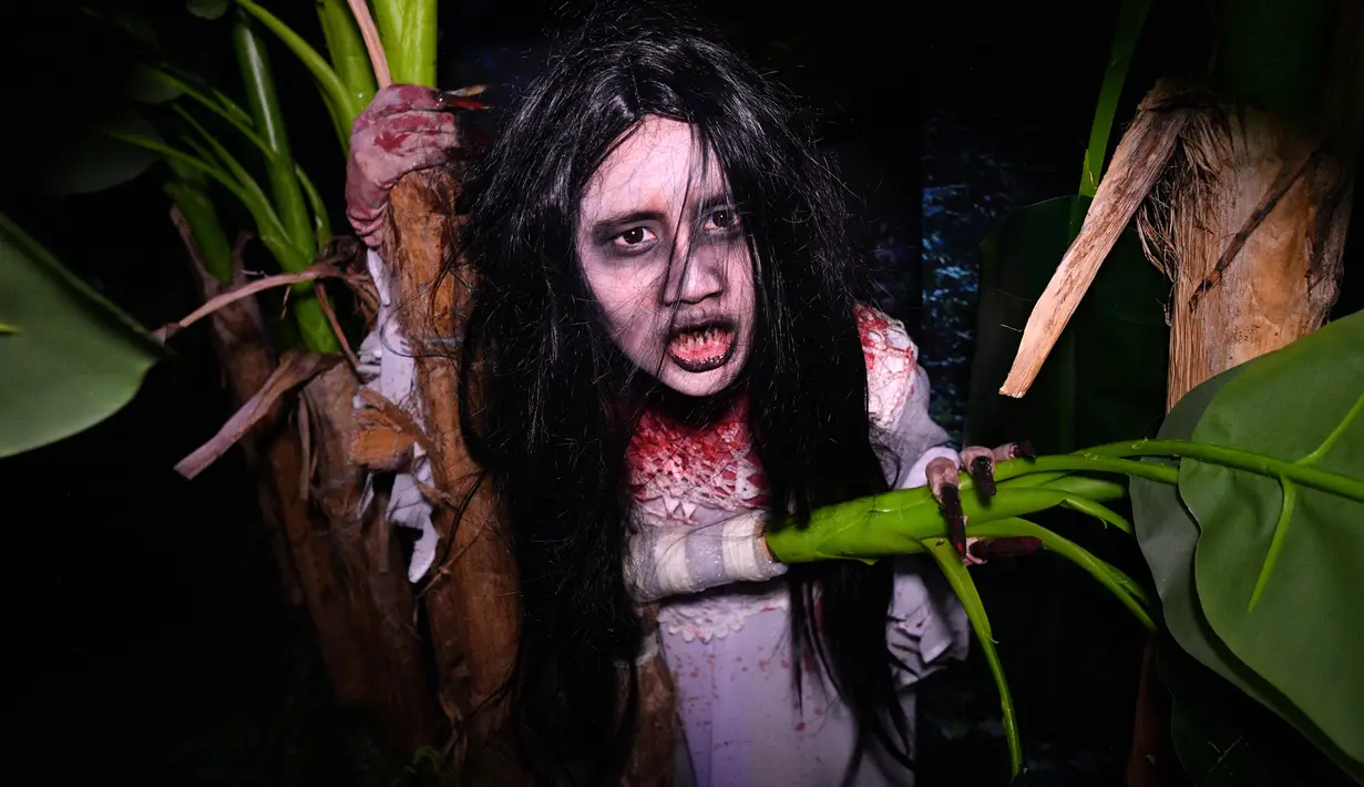 Seorang wanita mengenakan kostum menyeramkan saat preview media 'Halloween Horror Nights' di Universal Studio, Singapura, Senin (24/9). Wahana rumah hantu yang ada akan menghadirkan cerita horor khas Asia seperti Kuntilanak. (AFP/Roslan RAHMAN)
