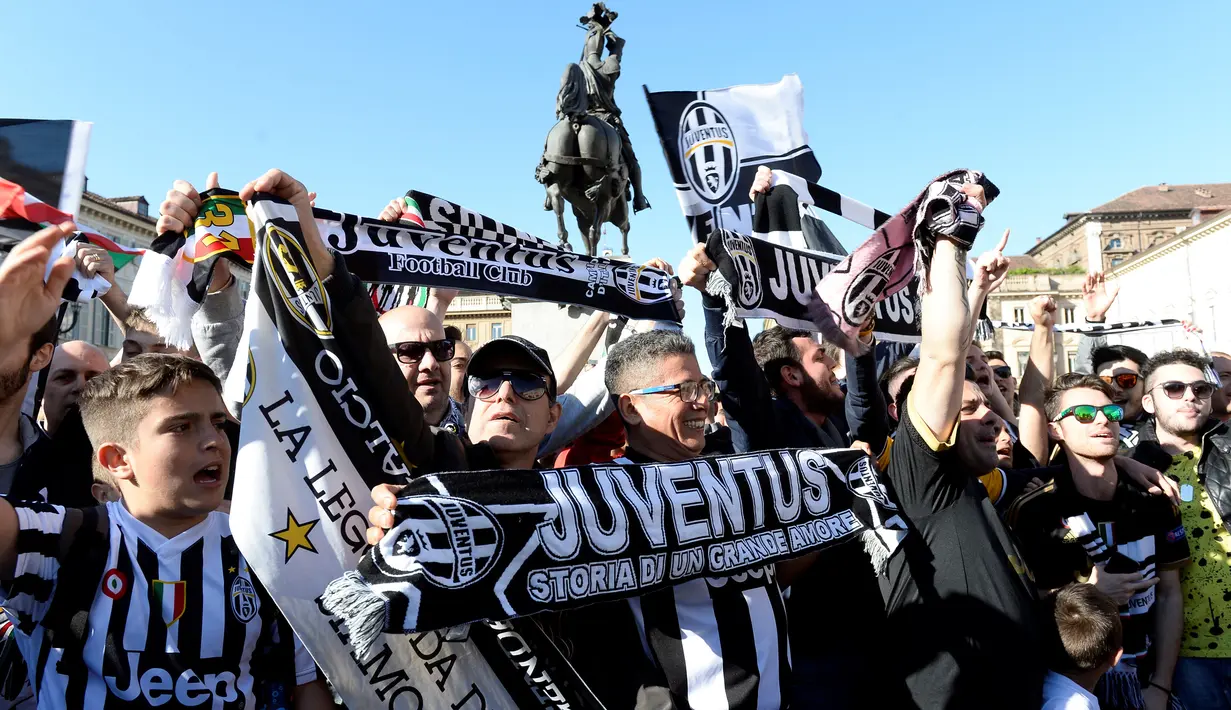 Suporter Juventus membentangkan shal merayakan kemenangan usai merebut gelar Serie A Italia di pusat kota Turin, Italia (25/4). Juventus berhak meraih gelar Scudetto mereka yang ke-34. (REUTERS/Giorgio Perottino)
