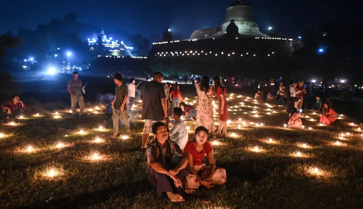 Orang-orang mengambil bagian dalam Festival Tazaungdaing di pagoda di Mrauk U, Rakhine, Myanmar, 18 November 2021. Tazaungdaing adalah Festival Bulan Purnama yang diadakan setiap tahun pada bulan purnama, bulan kedelapan dalam kalender Burma. (STR/AFP)