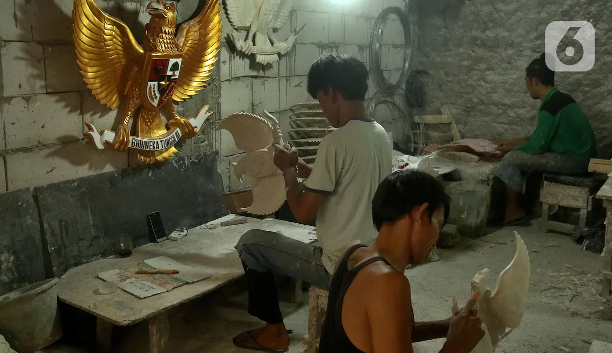 Perajin menyelesaikan pembuatan patung Garuda Pancasila yang terbuat dari serat kaca (fiberglas) di kawasan Kalimalang, Jakarta Timur, Selasa (16/8/2022). Patung Garuda Pancasila dijual dengan harga Rp 300 ribu hingga Rp 3 juta. (merdeka.com/Arie Basuki)