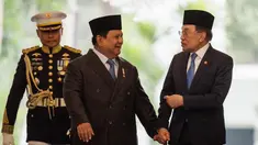 Presiden Republik Indonesia Prabowo Subianto (tengah) dan Perdana Menteri Malaysia Anwar Ibrahim (kanan) berjalan bersama menjelang pertemuan bilateral di Istana Kepresidenan, Jakarta pada 29 Juli 2025. (Yasuyoshi CHIBA/AFP)