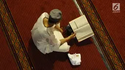 Umat muslim membaca Al-Quran pada hari ke-28 bulan suci Ramadan di Masjid Istiqlal, Jakarta, Selasa (12/6). Sejumlah umat muslim meningkatkan ibadah mereka dengan melakukan itikaf di Masjid Istiqlal. (Liputan6.com/Helmi Fithriansyah)