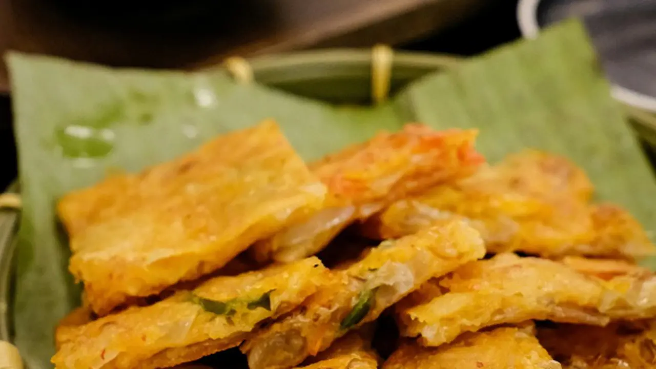 Ilustrasi Tempe Mendoan/Photo by Richard L: https://www.pexels.com/photo/crispy-fried-tempeh-on-banana-leaf-plate-32432716/