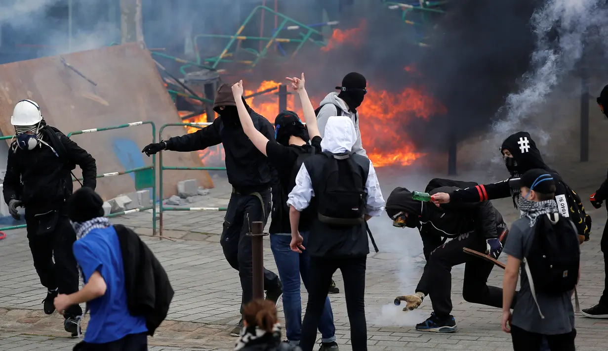 Demonstran menghadapi polisi anti huru hara dalam bentrokan di pusat kota Paris, Prancis, Kamis (28/4). Demonstrasi tersebut adalah unjuk rasa hari keempat yang dilakukan untuk menolak rancangan reformasi undang-undang buruh (REUTERS/Stephane Mahe)  
